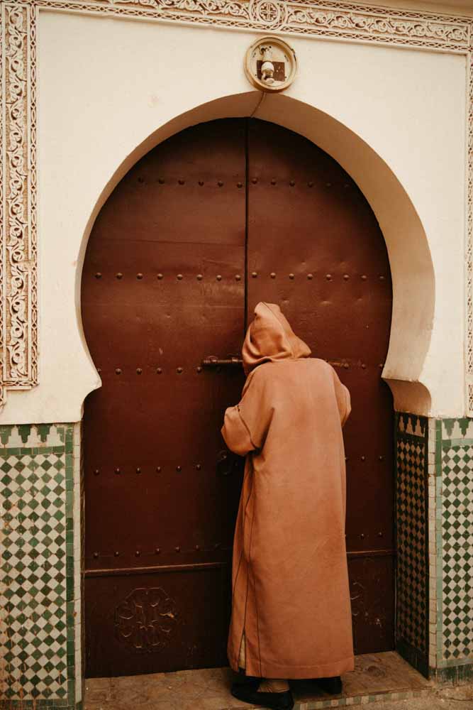 man in djellaba at moroccan mosque door